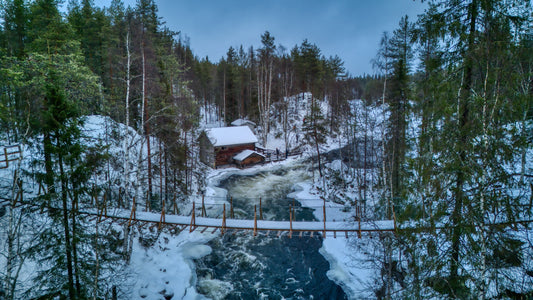 Pont suspendu et cabane au bord de la rivière hivernale
